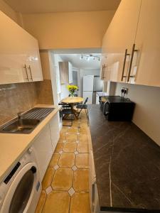 uma cozinha com um lavatório e uma mesa com um fogão em Nice Triple Room at 2 Iveragh Rd-7 em Dublin