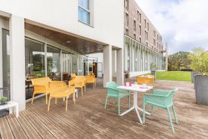 un patio con sedie e tavoli all'interno di un edificio di Appart’City Confort Nantes Ouest Saint-Herblain a Saint-Herblain