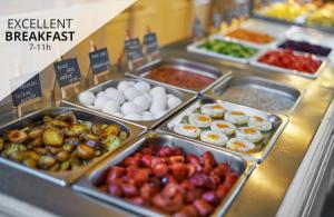 a buffet filled with different types of food in trays at Hotel Uno Prague in Prague