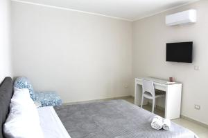 フォンターネ・ビアンケにあるMareOnda Homeのベッドとテレビ付きの机のある寝室