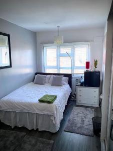 a bedroom with a white bed and a window at Room in apartment home-Stretford in Manchester