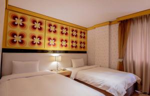 una camera d'albergo con due letti e un dipinto sul muro di Kenting Southern Dream Resort a Kenting
