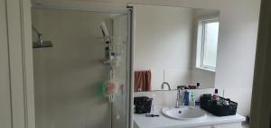 a bathroom with a shower with a sink and a mirror at Comfort Home in Wyndham Vale