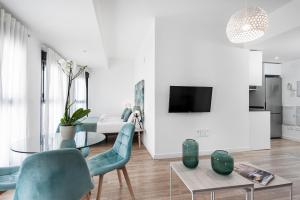 格拉納達的住宿－Apartamentos de Isabella，客厅配有玻璃桌和蓝色椅子