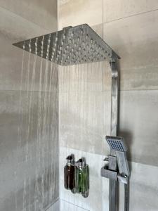 a shower with a shower head in a bathroom at Luxury Norwich City Centre Apartment - Free Parking in Norwich