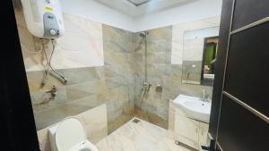 a bathroom with a shower and a toilet and a sink at Luxury Private Top Floor Apartment in Heart of Bahria Town in Lahore