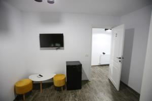 a room with a table and two stools and a tv at Casa Kevin in Năvodari