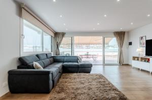 uma sala de estar com um sofá azul e uma grande janela em Catania Skyview Terrace: Your Urban Escape em Catânia