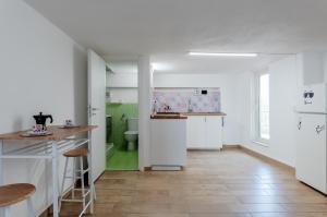uma cozinha com armários brancos e uma casa de banho verde em Catania Skyview Terrace: Your Urban Escape em Catânia