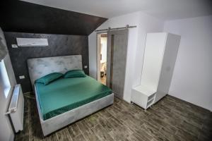 a bedroom with a green bed and a white cabinet at Casa Kevin in Năvodari