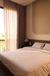 ein Schlafzimmer mit einem weißen Bett und einem Fenster in der Unterkunft Tuyet Suong Hotel&LoveHouse in Đà Nẵng