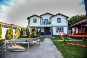 a house with a patio with hammocks in front of it at Casa Kevin in Năvodari