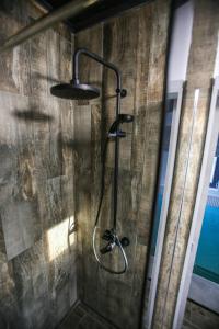 a shower in a bathroom with a wooden wall at Casa Kevin in Năvodari +38 photos