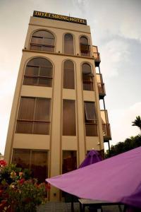 Tuyet Suong Hotel&LoveHouse في دا نانغ: مبنى أمامه مظلة أرجوانية