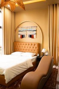 Tuyet Suong Hotel&LoveHouse في دا نانغ: غرفة نوم فيها سرير وكرسي