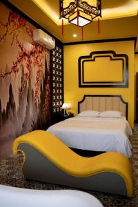 ein Schlafzimmer mit einem Bett und einer gelben Bank in der Unterkunft Tuyet Suong Hotel&LoveHouse in Đà Nẵng