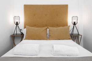 a bedroom with a large bed with two lamps at Apartamentos de Isabella in Granada