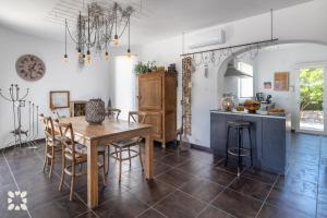 Villa Atmosfera by Abahana Villas في Fanadix: مطبخ وغرفة طعام مع طاولة وكراسي خشبية