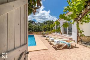 Villa Atmosfera by Abahana Villas في Fanadix: صف كراسي الصالة بجانب المسبح