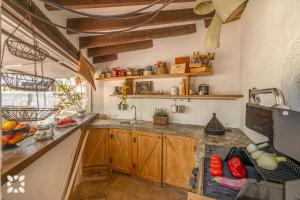 Villa Atmosfera by Abahana Villas في Fanadix: مطبخ مع خزائن خشبية ومغسلة