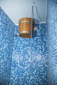 a blue tiled bathroom with a barrel on the wall at Family Hotel Emaly 2 in Sapareva Banya