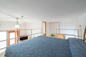 een slaapkamer met een bed met een blauwe deken bij Monolocale Ginetto in Calasetta