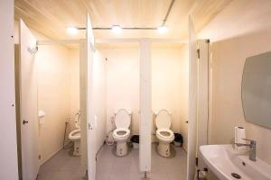 La salle de bains est pourvue de 2 toilettes et d'un lavabo. dans l'établissement My Cocoon Hostel แจ้งวัฒนะ, à Nonthaburi