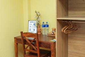 a wooden table with a chair and bottles of water at Peace and Joy Guest House in Pātan