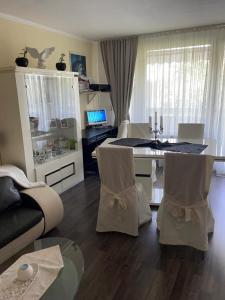 Ferienwohnung في كولونيا: غرفة معيشة مع طاولة وكراسي وأريكة