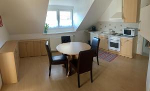 een keuken met een tafel en stoelen in een kamer bij Gösser BACHGASSLHOF -- Bed and Breakfast -- Apartments in Leoben