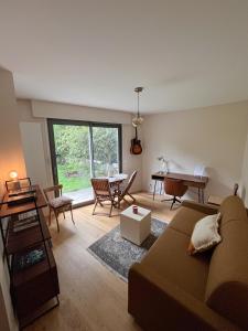 ein Wohnzimmer mit einem Sofa und einem Tisch in der Unterkunft Studio agréable & charmant + WI-FI in Neuilly-sur-Seine