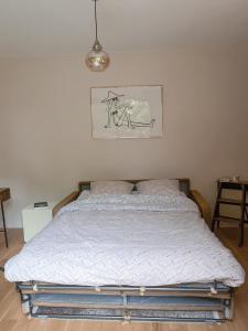 ein Bett in einem Schlafzimmer mit einem Bild an der Wand in der Unterkunft Studio agréable & charmant + WI-FI in Neuilly-sur-Seine