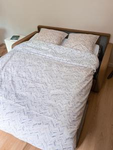 ein Bett mit einer weißen Bettdecke und 2 Kissen in der Unterkunft Studio agréable & charmant + WI-FI in Neuilly-sur-Seine