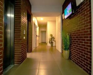 - un couloir avec un mur en briques et une télévision murale dans l'établissement Spacious Apartment – fully furnished and equipped, à Hadera