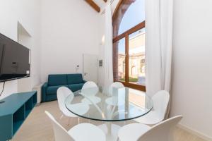 a dining room with a glass table and white chairs at Pellestrina Domus - Italianflat in Venice