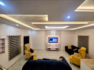 a living room with couches and a flat screen tv at PLOT 36 APARTMENT in Lekki