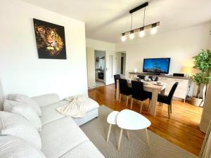 sala de estar con sofá blanco y mesa en Appartement Le Cosy - Rénové - 3 Chambres en Oyonnax