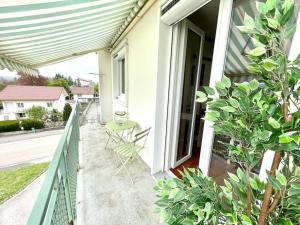 porche con barandilla verde, mesa y sillas en Appartement Le Cosy - Rénové - 3 Chambres en Oyonnax