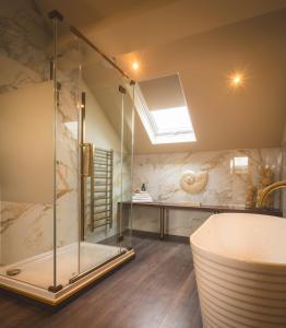 Das Bad ist mit einer Badewanne und einer Glasdusche ausgestattet. in der Unterkunft Howfield Hotel in Merthyr Tydfil