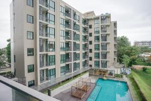 an apartment building with a pool in front of it at Brique Hotel Chiangmai in Chiang Mai