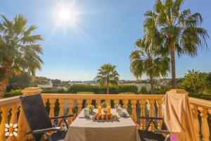 ein Tisch und Stühle auf einem Balkon mit Palmen in der Unterkunft Villa Aurora by Abahana Villas in Benissa