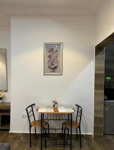 a dining room table with two chairs and a picture on the wall at Cozy Haven Suite in Accra