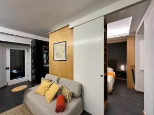 a living room with a couch and a bedroom at Apartamento acolhedor no centro da cidade, com pátio privado. in Angra do Heroísmo