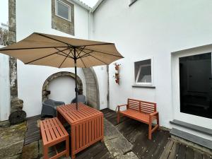 a patio with a table and two chairs and an umbrella at Apartamento acolhedor no centro da cidade, com pátio privado. in Angra do Heroísmo