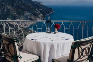 a table with a view of the amalfi coast at Caruso, A Belmond Hotel, Amalfi Coast in Ravello