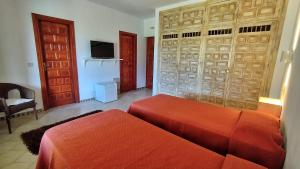 1 Schlafzimmer mit 2 Betten, einem TV und einem Sofa in der Unterkunft Cortijo de la luna la casita in Taramay