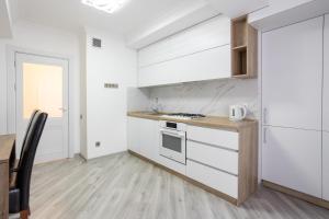 kuchnia z białymi szafkami i blatem w obiekcie Apartament in the Center Area w mieście Sectorul Botanica