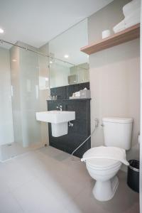 La salle de bains est pourvue de toilettes et d'un lavabo. dans l'établissement Brique Hotel Chiangmai, à Chiang Mai
