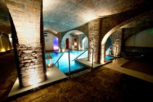 a swimming pool in a building with a brick wall at Titanic Hotel Liverpool in Liverpool
