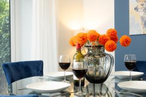 een tafel met twee glazen wijn en een vaas met bloemen bij Stratford House in Braunstone
